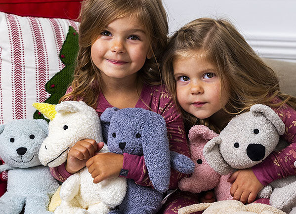 Two children holding plush zoo animals